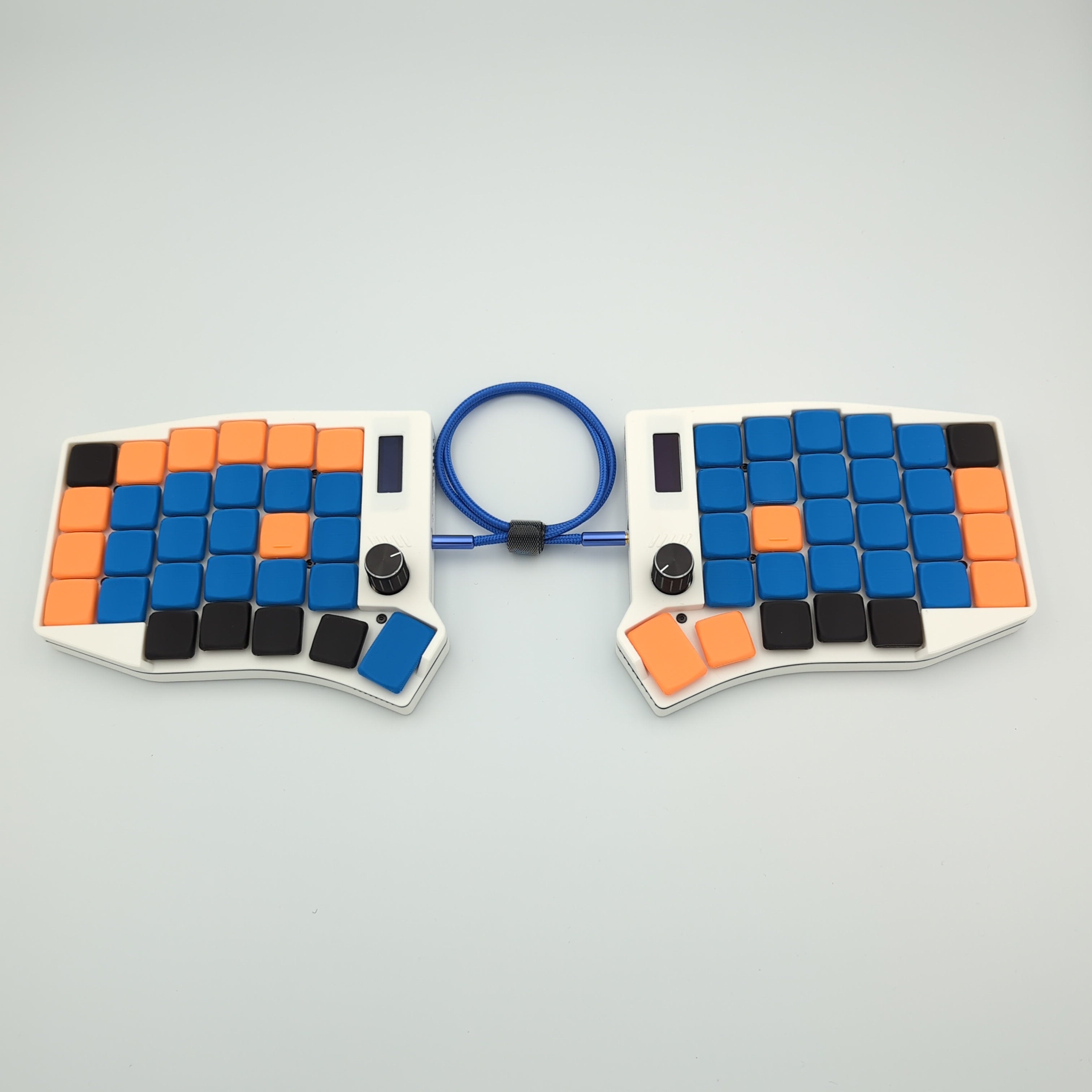 Custom colored Sofle keyboard with blue, orange, and black keys on a gray background